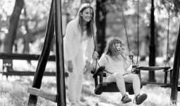 Handicapped child enjoying the swing outdoors with sister